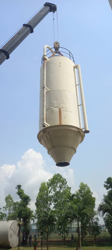 Vertical processing container hanging from crane hoist